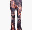 a photo of a woman wearing a black and orange floral print pants