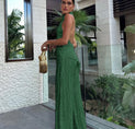 a woman wearing a green pleaed dress