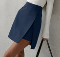 a woman wearing a white sweater and blue skirt