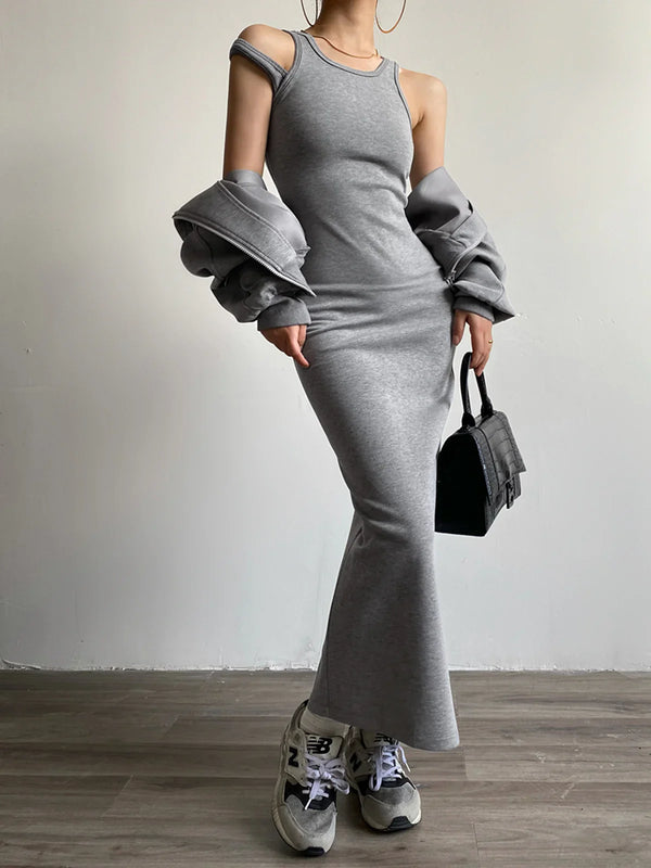 a woman wearing a grey dress and sneakers