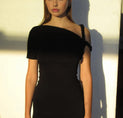 a woman in a black dress posing for the camera