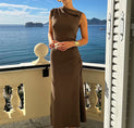 a woman in a brown dress standing on a balcony