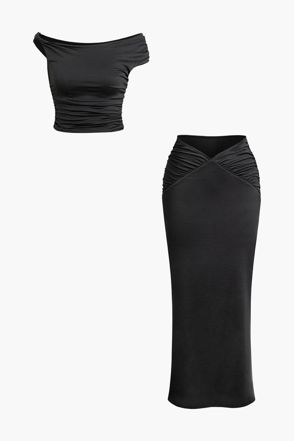 a woman wearing a black top and skirt