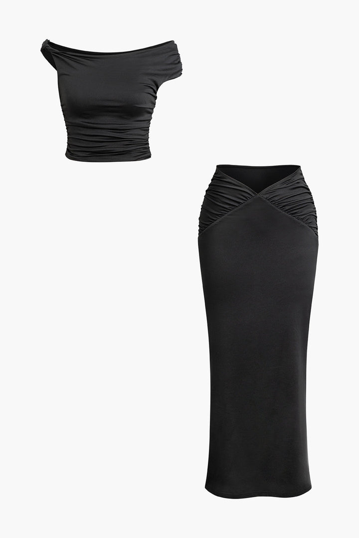 a woman wearing a black top and skirt