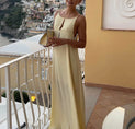 a woman in a yellow dress standing on a balcony