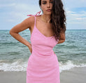 a woman in a pink dress on the beach