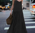 a woman in a black dress crossing the street
