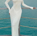 a woman in a white dress standing on a dock