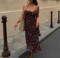 a woman walking down the street wearing a floral dress