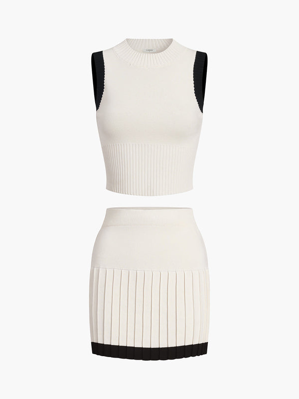 a white dress with a black top and pleaed skirt