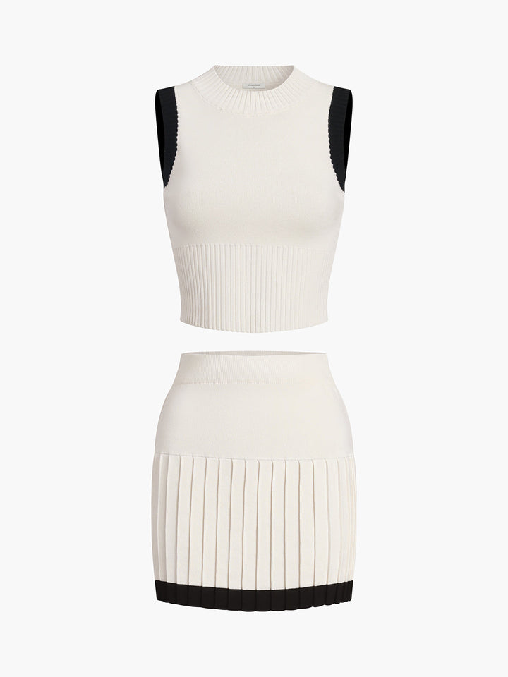 a white dress with a black top and pleaed skirt