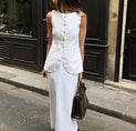 a woman in a white dress is walking down the street
