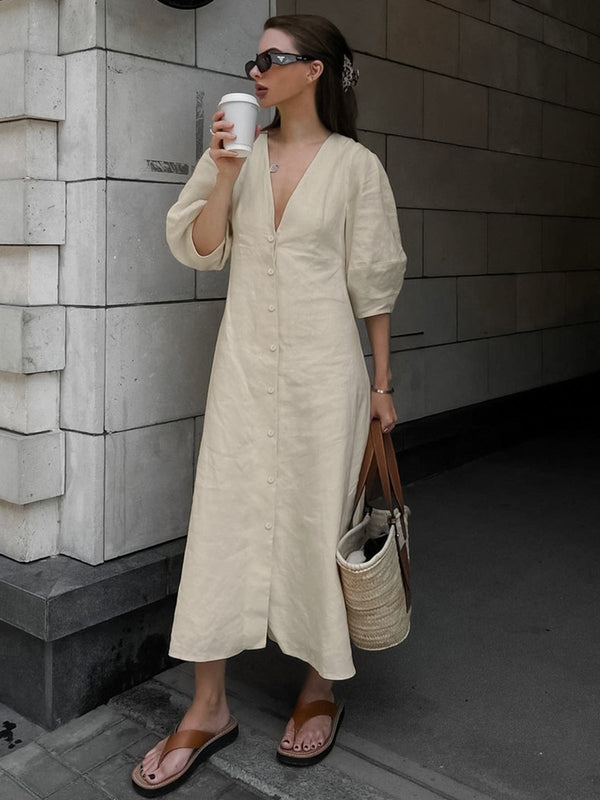 a woman standing on a sidewalk holding a cup of coffee