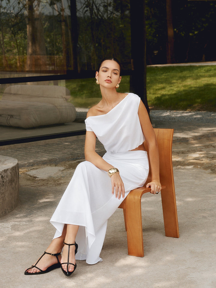 a woman in a white dress sitting on a bench