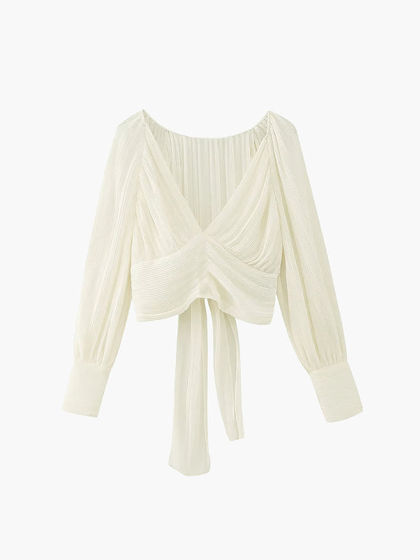 a white blouse with long sleeves and a knotted front