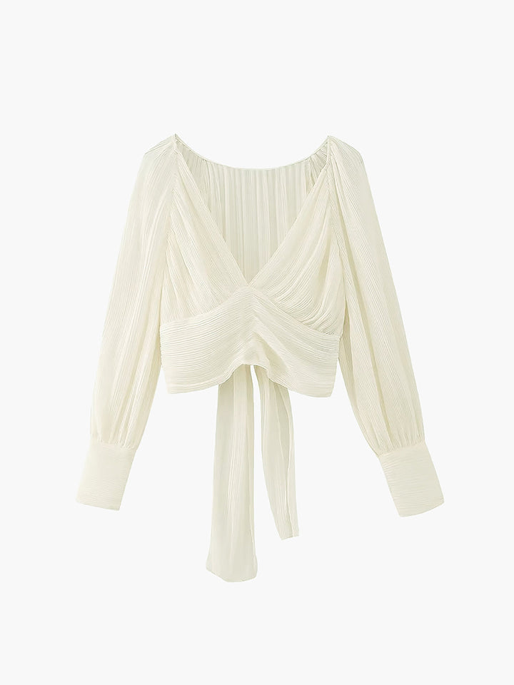 a white blouse with long sleeves and a knotted front