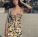 a woman in a black and yellow floral dress