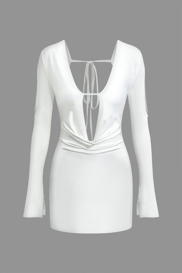 a white dress with long sleeves and a plunging neckline