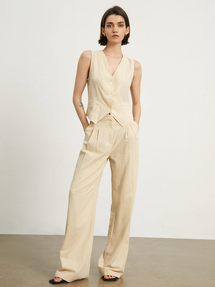 a woman wearing a beige jumpsuit and black sandals