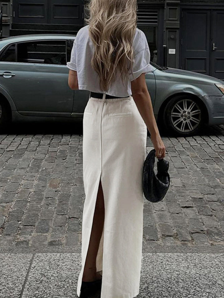a woman walking down the street in a white skirt