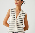 a woman wearing a white and black striped vest