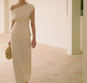 a woman in a white dress standing in a room