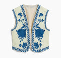 a white vest with blue flowers on it