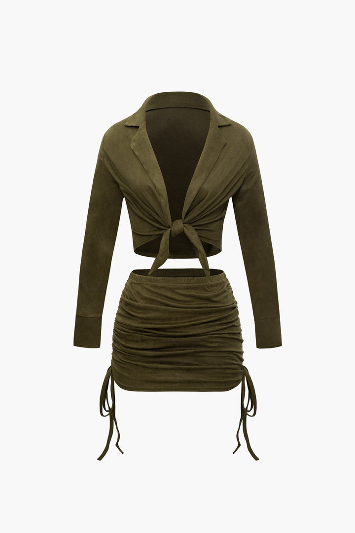 a woman wearing a green jacket and skirt