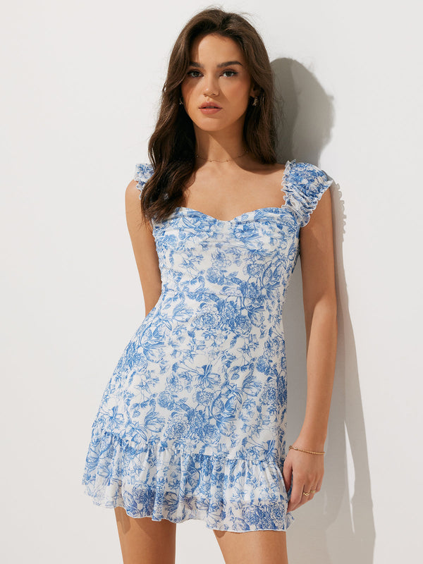 a woman wearing a blue and white floral print dress