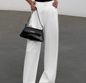 a woman in a black top and white pants