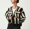 a woman wearing a black and white cardigan sweater