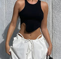 a woman wearing a black crop top and white shorts