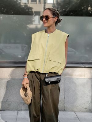 a woman in a yellow top and green pants