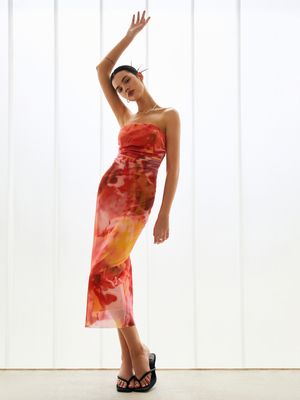 a woman in a red dress standing in front of a white wall