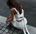a woman in a white dress sitting on the ground