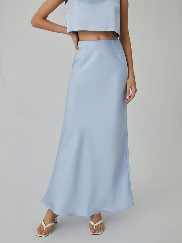 a woman wearing a blue crop top and skirt