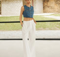 a woman in a blue top and white pants
