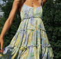a woman wearing a yellow and blue floral print dress
