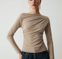 a woman in a tan sweater and jeans
