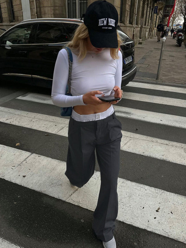 a woman walking across a crosswalk on a street