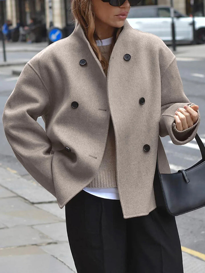 a woman in black pants and a beige coat
