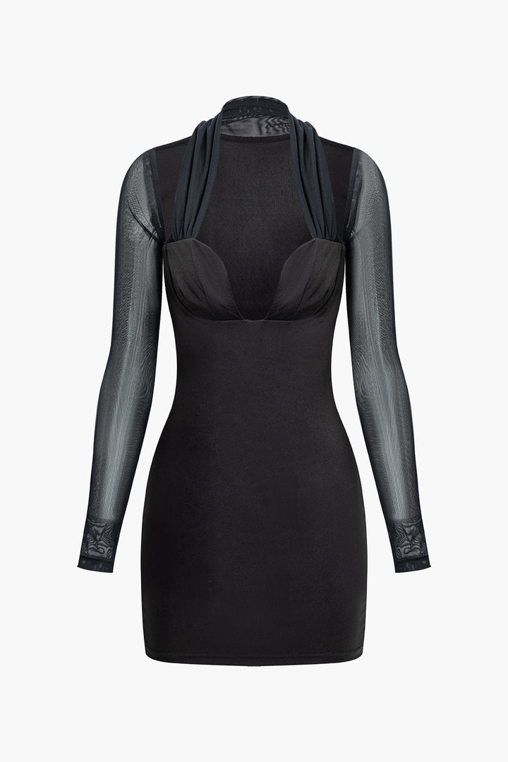 a woman wearing a black dress with sheer sleeves