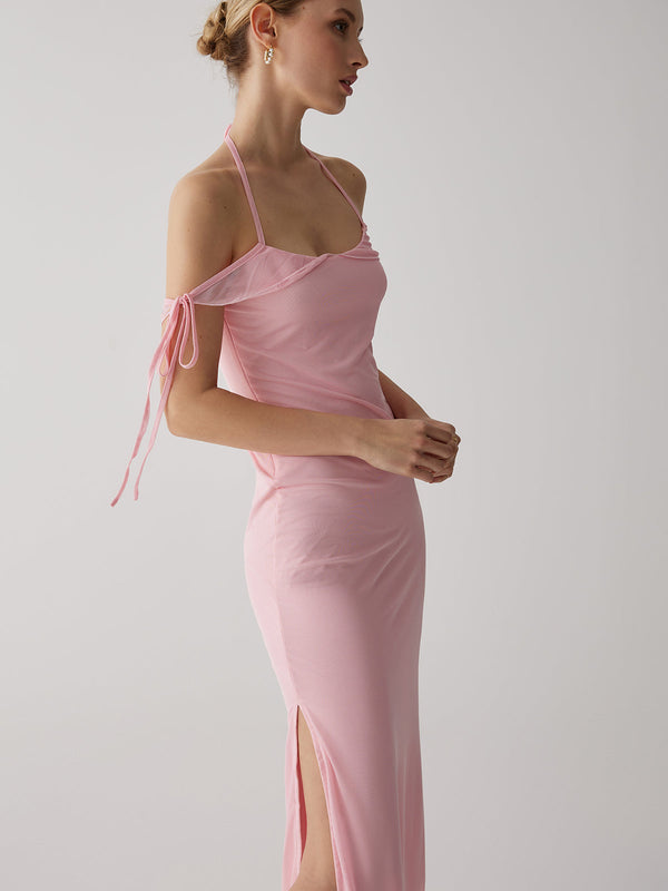 a woman wearing a pink dress with a side slit