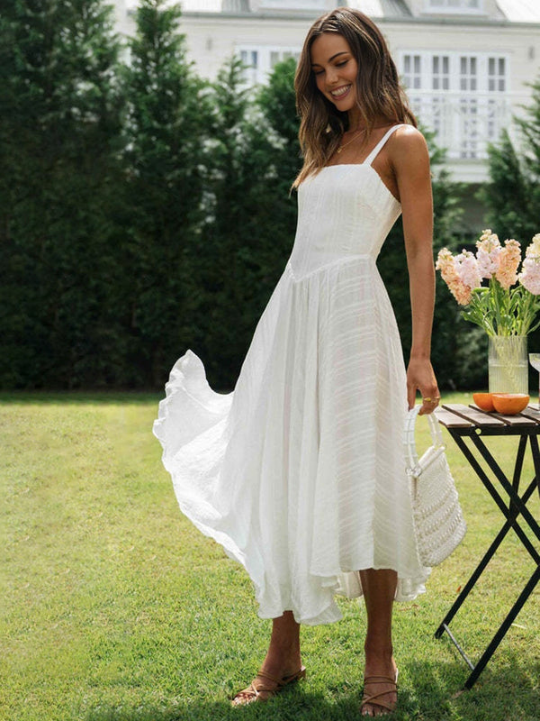 a woman in a white dress standing on a lawn