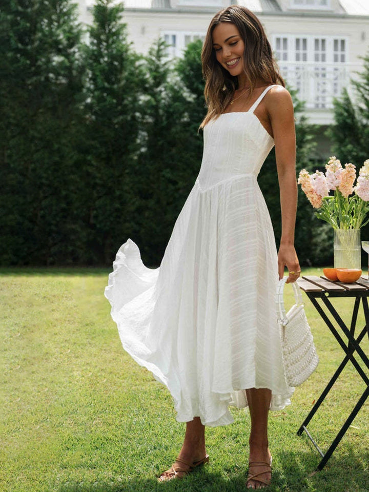 a woman in a white dress standing on a lawn