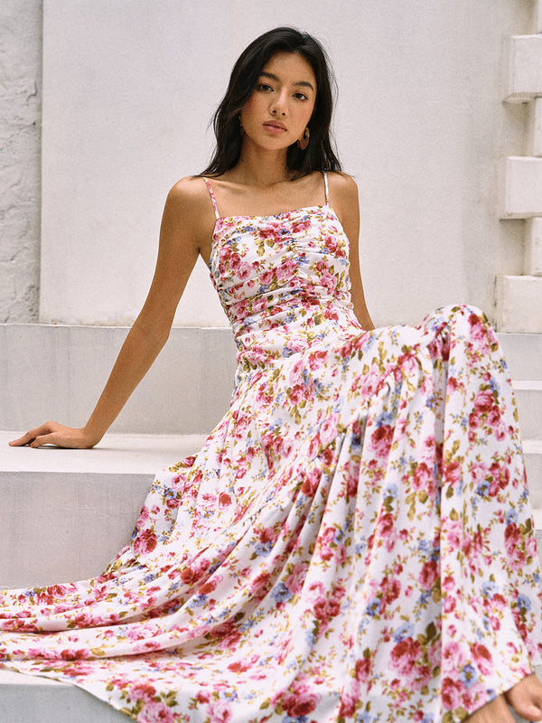 a woman sitting on a ledge wearing a floral dress
