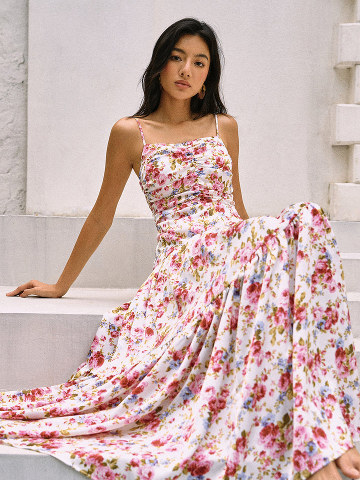 a woman sitting on a ledge wearing a floral dress