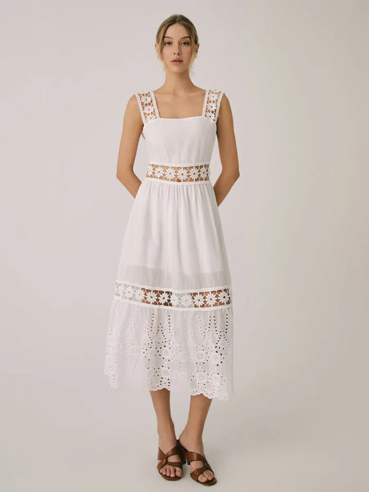 a woman wearing a white dress and sandals