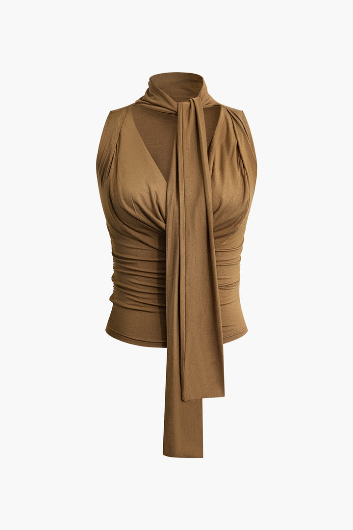 a woman wearing a brown top with a tie around her neck