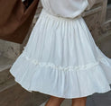 a little girl in a white dress is walking down the street